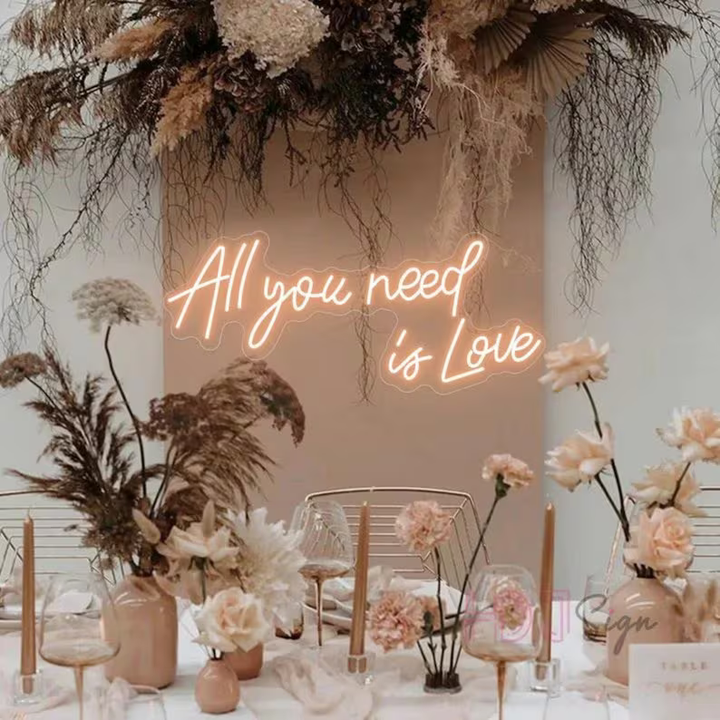 All You Need Is Love Wedding Neon Sign by Neon.Shop glowing in warm LED light on a wedding décor backdrop”