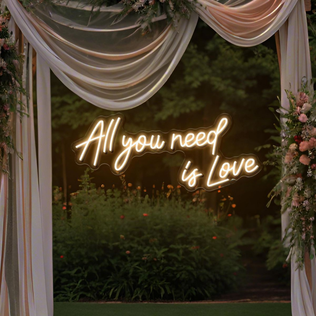 All You Need Is Love Wedding Neon Sign by Neon.Shop glowing in warm LED light on a wedding décor backdrop”