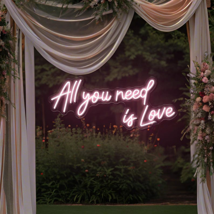 All You Need Is Love Wedding Neon Sign by Neon.Shop glowing in warm LED light on a wedding décor backdrop”