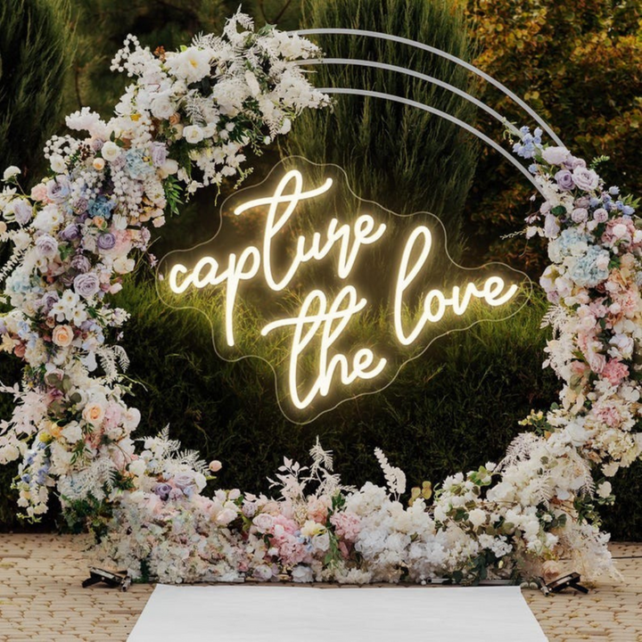 Capture the Love wedding LED neon sign glowing on photo booth backdrop – Neon.Shop