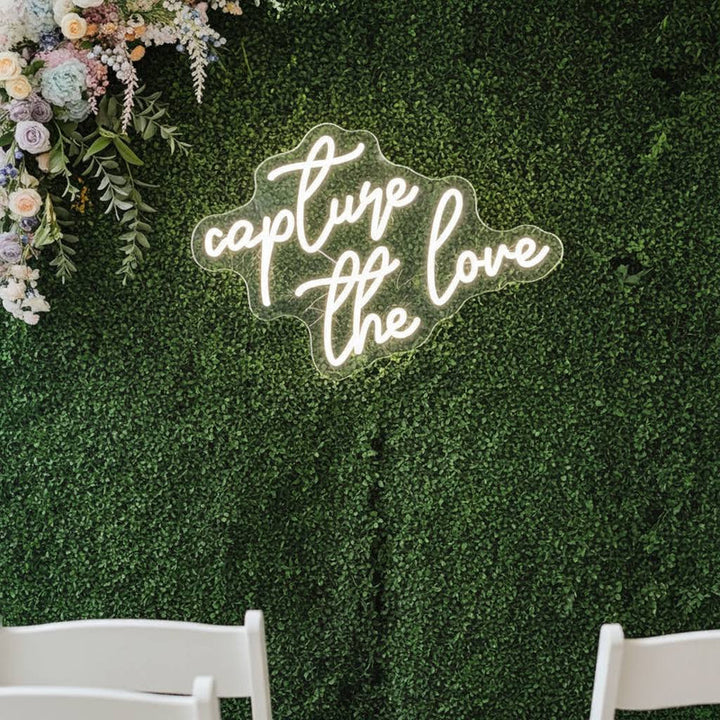 Capture the Love wedding LED neon sign glowing on photo booth backdrop – Neon.Shop
