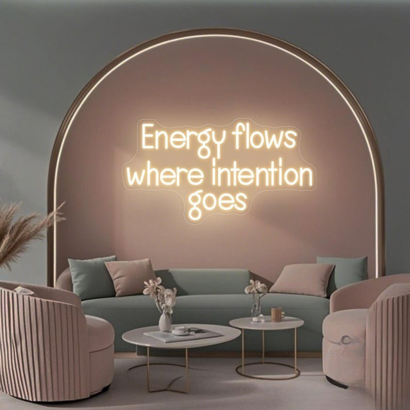 Energy Flows Where Intention Goes” neon sign glowing on a wall, motivational quote décor for office, studio, or home by Neon.Shop.