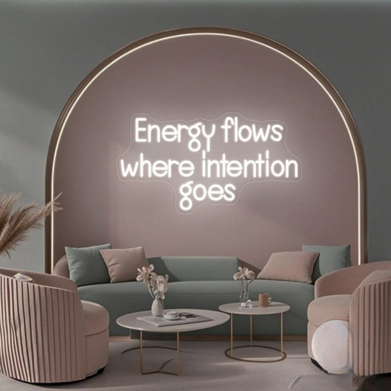 Energy Flows Where Intention Goes” neon sign glowing on a wall, motivational quote décor for office, studio, or home by Neon.Shop.