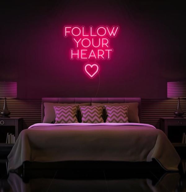 Follow Your Heart” neon sign glowing on a wall, motivational quote décor for bedroom or office by Neon.Shop.