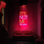 It’s Not Me It’s You neon sign displayed in bar or party setup by Neon.Shop