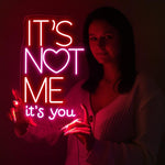 It’s Not Me It’s You neon sign displayed in bar or party setup by Neon.Shop