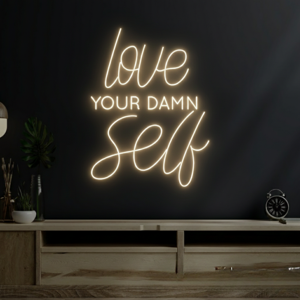 Love Your Damn Self LED neon sign by Neon.Shop glowing on a modern wall as bold and inspirational neon décor