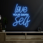 Love Your Damn Self LED neon sign by Neon.Shop glowing on a modern wall as bold and inspirational neon décor