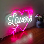 Lovers with arrow inside the heart Valentine’s Day LED neon sign glowing in romantic pink tones by Neon.Shop