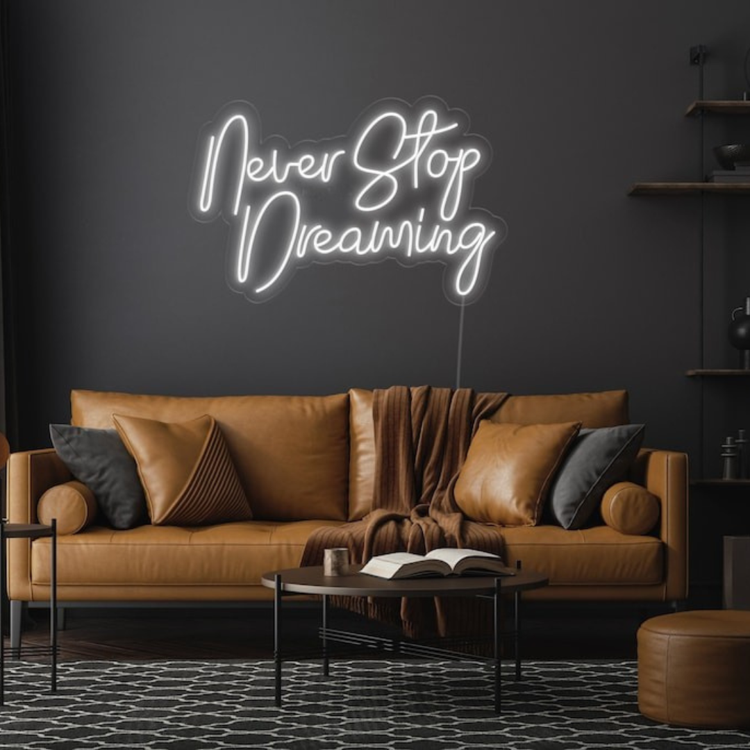 Never Stop Dreaming LED neon sign by Neon.Shop glowing on a modern interior wall as inspirational neon wall decor