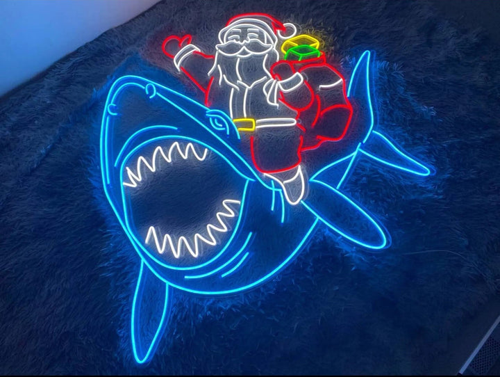Santa Claus riding a shark Merry Christmas LED neon sign glowing in vibrant festive colors by Neon.Shop.