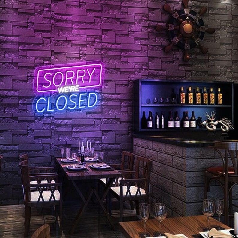 Sorry We Are Closed Business Neon Sign by Neon.Shop glowing above a shop entrance, letting customers know the business is closed