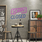 Sorry We Are Closed Business Neon Sign by Neon.Shop glowing above a shop entrance, letting customers know the business is closed
