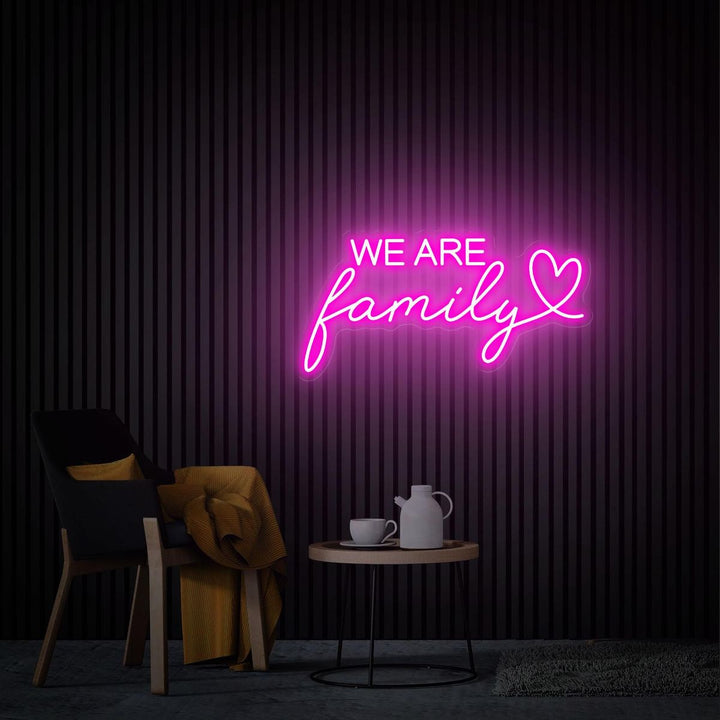 We Are Family LED neon sign by Neon.Shop glowing on a wall as inspirational and cozy neon home décor